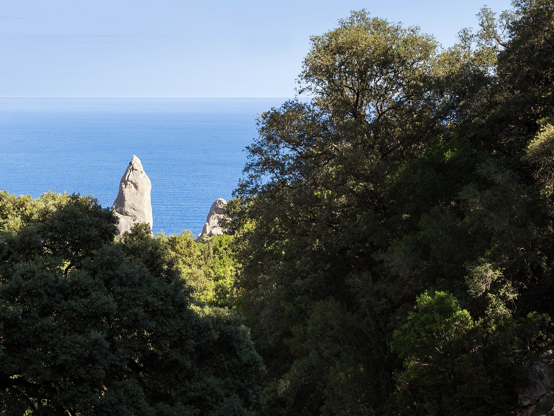 Cala Goloritzé: weißer Kiesel, flaches Wasser und der Kalksteinturm der Aguglia